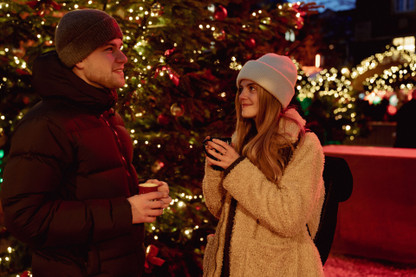 Junges Pärchen trinkt Glühwein auf dem Weihnachtsmarkt