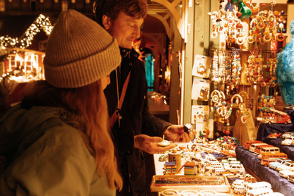 Junges Pärchen stöbert zwischen Weihnachtsartikeln auf dem Kieler Weihnachtsmarkt